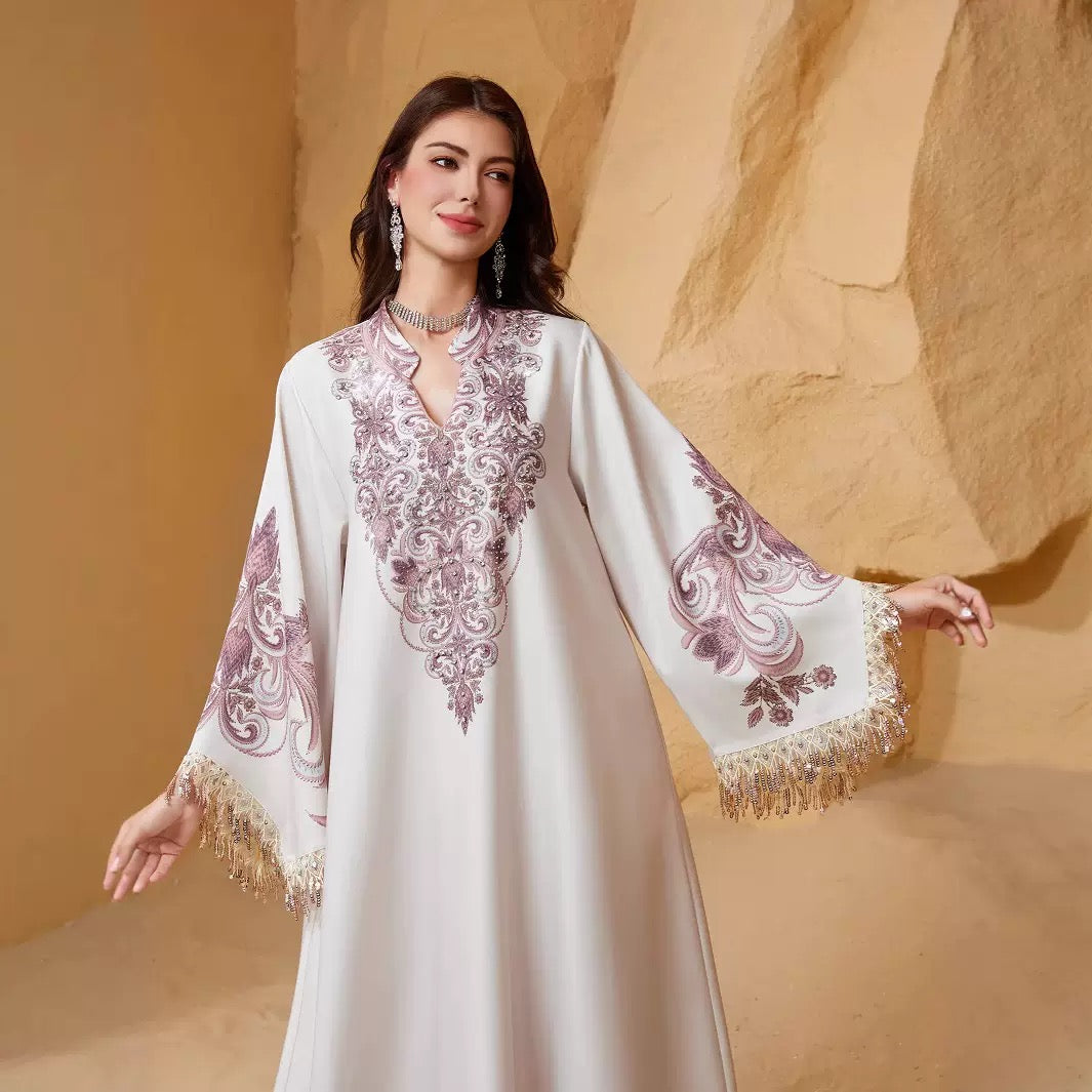 Close-up of white and mauve abaya with rhinestone chest print and fringe cuffs
